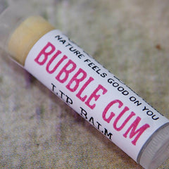 Lip balm tube with white label, pink "Bubble Gum" text, and clear plastic casing