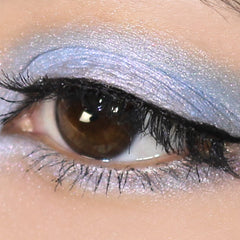 Eye makeup blue eyeshadow with pink and turquoise shimmer applied to eye, close-up