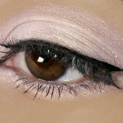 Eye makeup with light pink eyeshadow, black eyeliner, and brown eye color close-up view