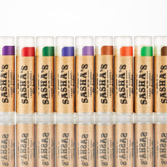 Lip balm tubes with various colored tops and brown paper labels, Sasha's brand visible