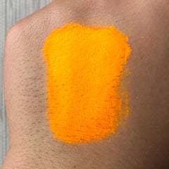 Side view of Tala neon bright orange eye shadow pigment pot showing vibrant matte texture