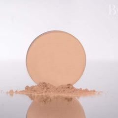 Powder compact with beige color and powder pile, reflected on surface