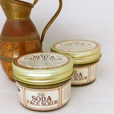 Facial Cleanser: Glass jars with gold lids, product label, and copper pitcher in background