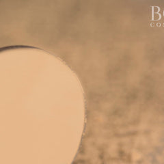 Hand applying matte yellow eyeshadow to eyelid with fingertip, showcasing smooth pigment blend