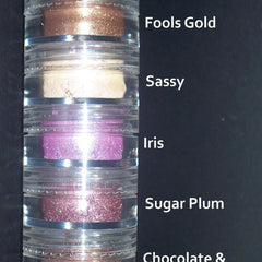 Close-up of seven stackable eyeshadow pans in warm hazel shades with shimmer and matte finishes