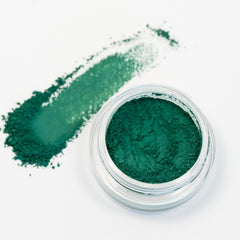 Side view of matte green eyeshadow compact with matching eyeliner, showcasing textured surface and square packaging