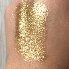 Gold glitter on skin, showing texture and shimmer, applied to arm