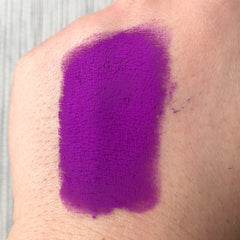 Purple swatch on skin with textured finish and visible skin texture