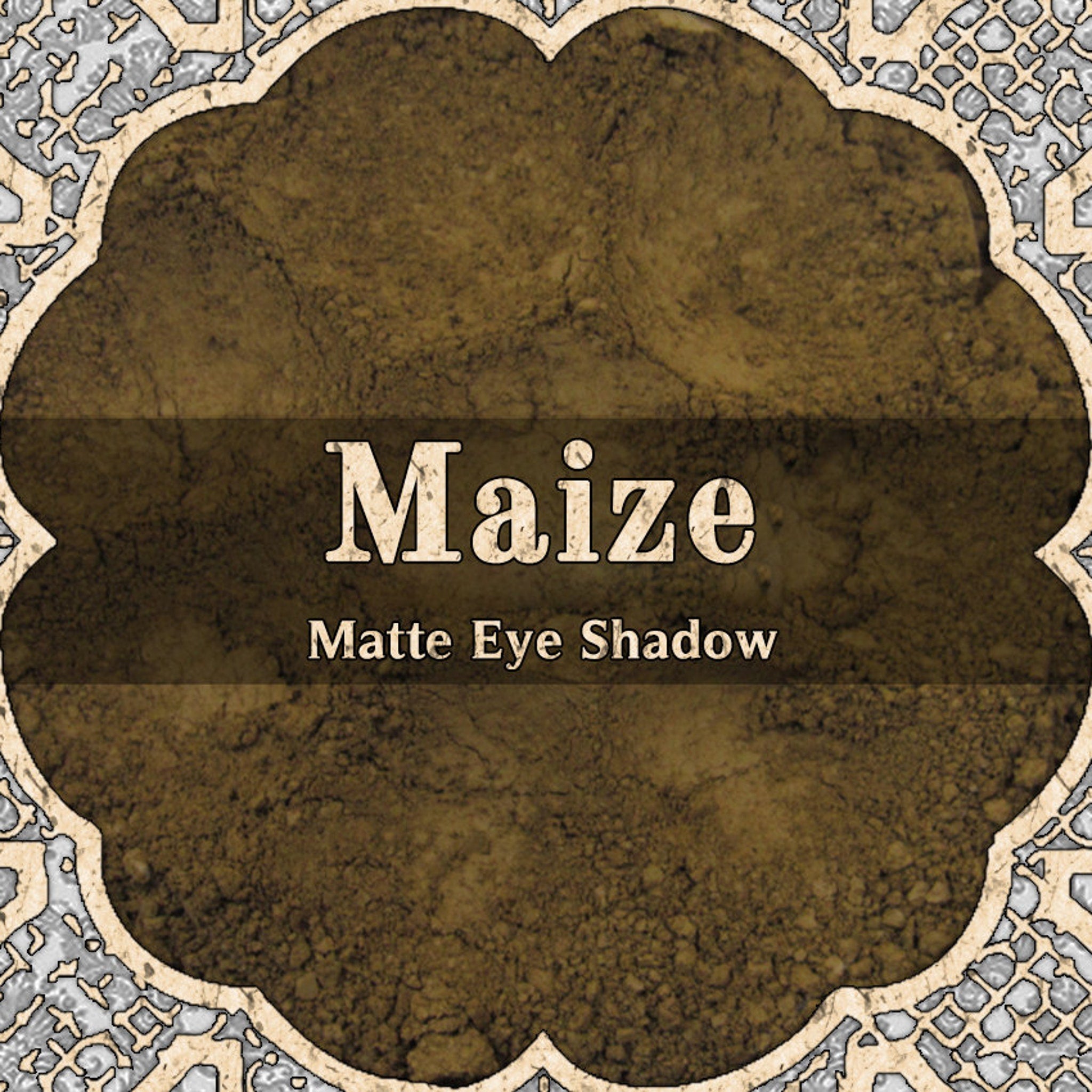 Matte eyeshadow powder, dark gold color, with Maize brand text and decorative border