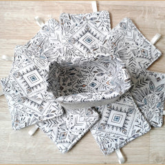 Fabric basket with matching patterned coasters, white with black and muted color design, fabric with ribbon loops