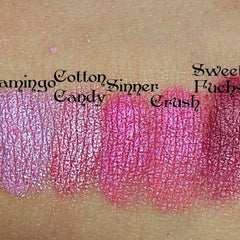 Close-up of vibrant fuchsia mineral eyeshadow with shimmering pink undertones in compact case