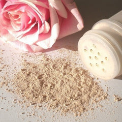 Rose face cleanser with pink rose, beige powder, and white shaker jar
