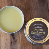 Lip balm in silver tin with yellow balm and Herbs and Soil Apothecary label