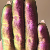 Eye shadow, iridescent pink and green pigment on fingers, close-up view