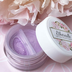 Lilac eyeshadow with peach pink duochrome, jar with Etherealle logo, close-up