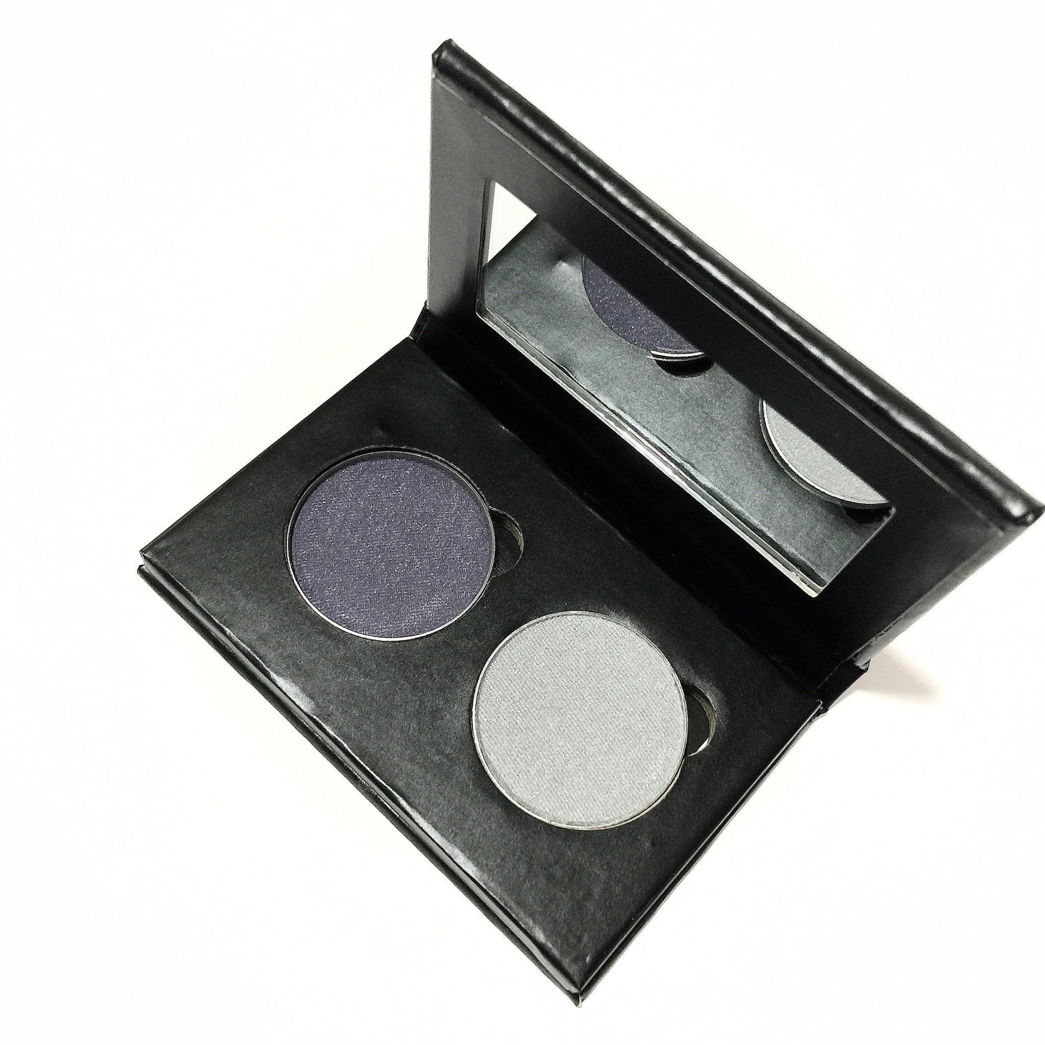 Eye shadow duo with dark gray and light gray colors in a black palette with a mirror