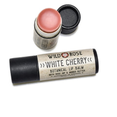 Lip balm with pink balm, black cap, and "Wild Rose White Cherry" text on tube