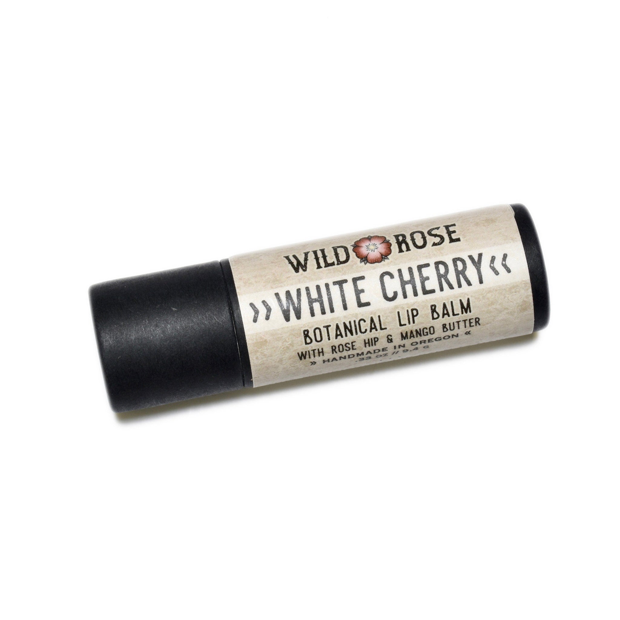 Lip balm tube with Wild Rose text, black and tan, angled on white background