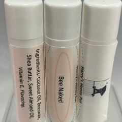 Lip balm tubes with white caps, light pink labels, and text including "Bee Naked" and "Harry's Honey Pot