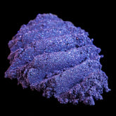 Dark purple loose mineral eyeshadow with metallic indigo shift and sparkling glitter particles in a jar.