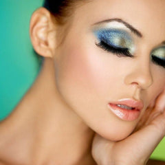 Close-up of five jewel-toned glitter eyeshadows in emerald, sapphire, amethyst, ruby, and topaz shades with shimmer finish