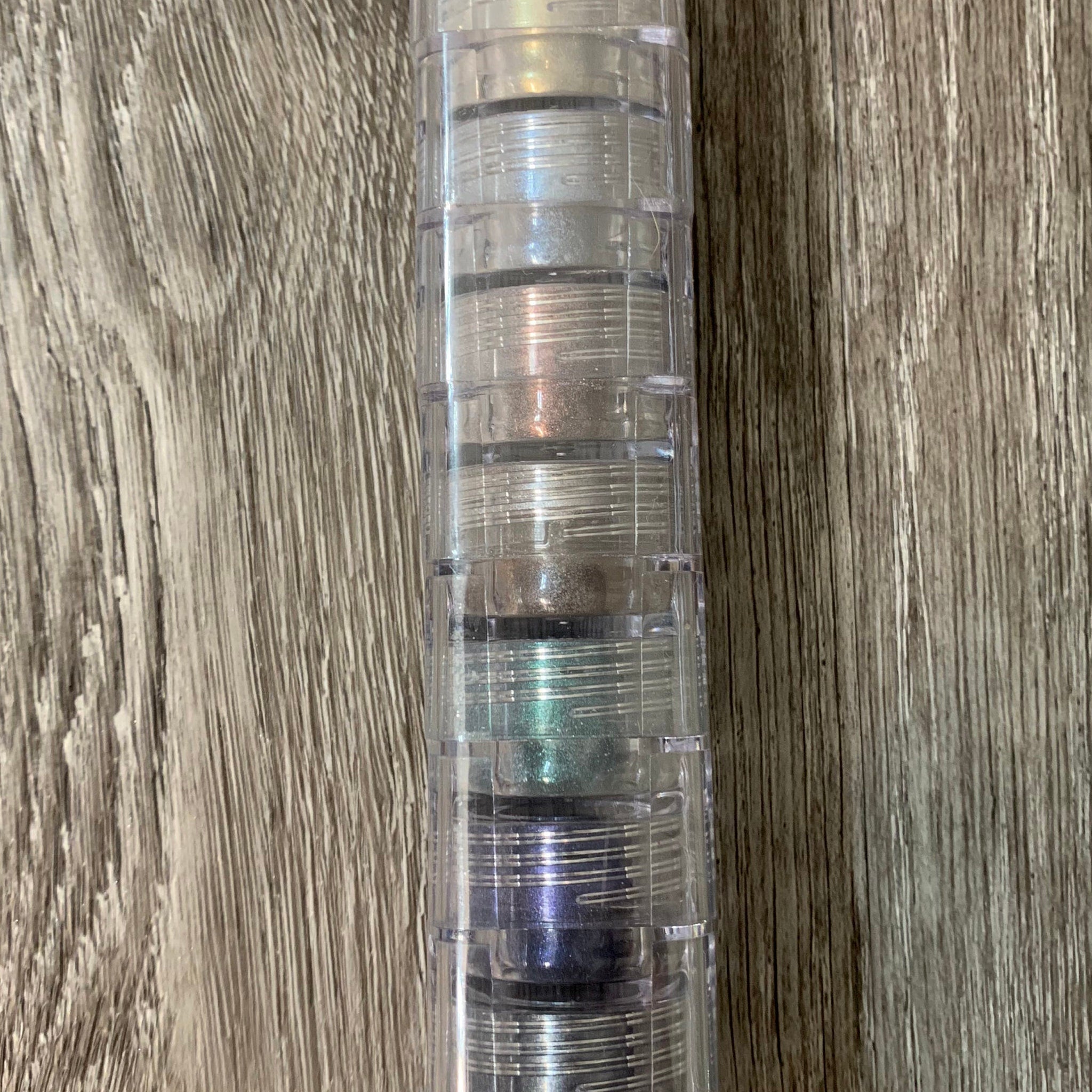 Mineral eyeshadow stack with clear plastic container and various colors visible