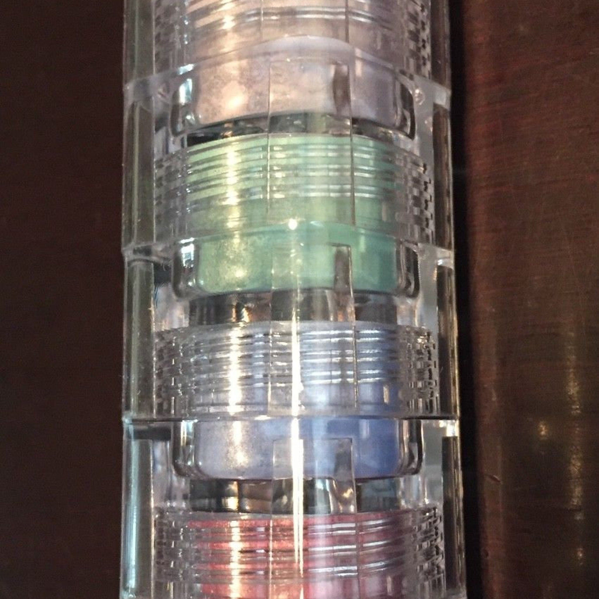 Mineral eyeshadow stack with clear plastic container, multiple colors, and layered design