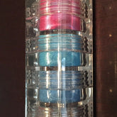 Mineral eyeshadow stack with pink, blue, and clear plastic containers, True Colors USA brand