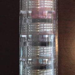 Eye shadow stack with clear plastic casing and multiple shades of eye shadow visible