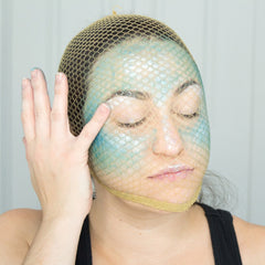 Side view of holographic vegan eye shadow palette showcasing teal, peach pink, and white sparkles in Halloween-themed packaging