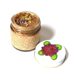 Honey scrub jar with brown scrub, clear glass, and floral lid design