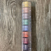 Eye makeup stack with clear plastic case and colorful eyeshadows on wood background