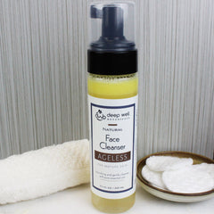 Face cleanser bottle with yellow liquid, black pump, and Deep Well Botanicals label next to a white washcloth