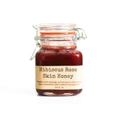 Facial cleanser in a glass jar with red contents, orange seal, and metal clasp, DBTS label visible