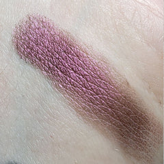 Close-up of Invoke Thee Eye Shadow palette showing shimmering bronze and plum shades with smooth, blendable texture