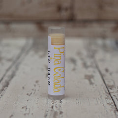 Lip balm tube with white label, yellow text, and clear plastic cap and base