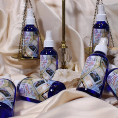 Rose water spray bottles, blue glass, white spray top, "FLEURESSENCE" label visible