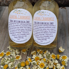 Facial toner bottles with white labels, clear liquid, and dried chamomile flowers on wood surface