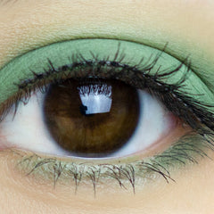 Green eyeshadow with brown eye and black eyelashes, close-up view
