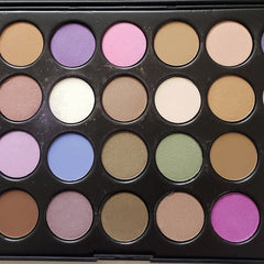 Close-up of 28 vibrant eyeshadow shades in matte, shimmer, and metallic finishes arranged in circular pans