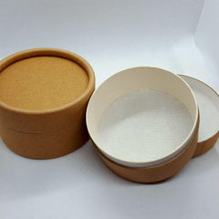 Stacked kraft paper jars with matte black lids for skincare creams and serums