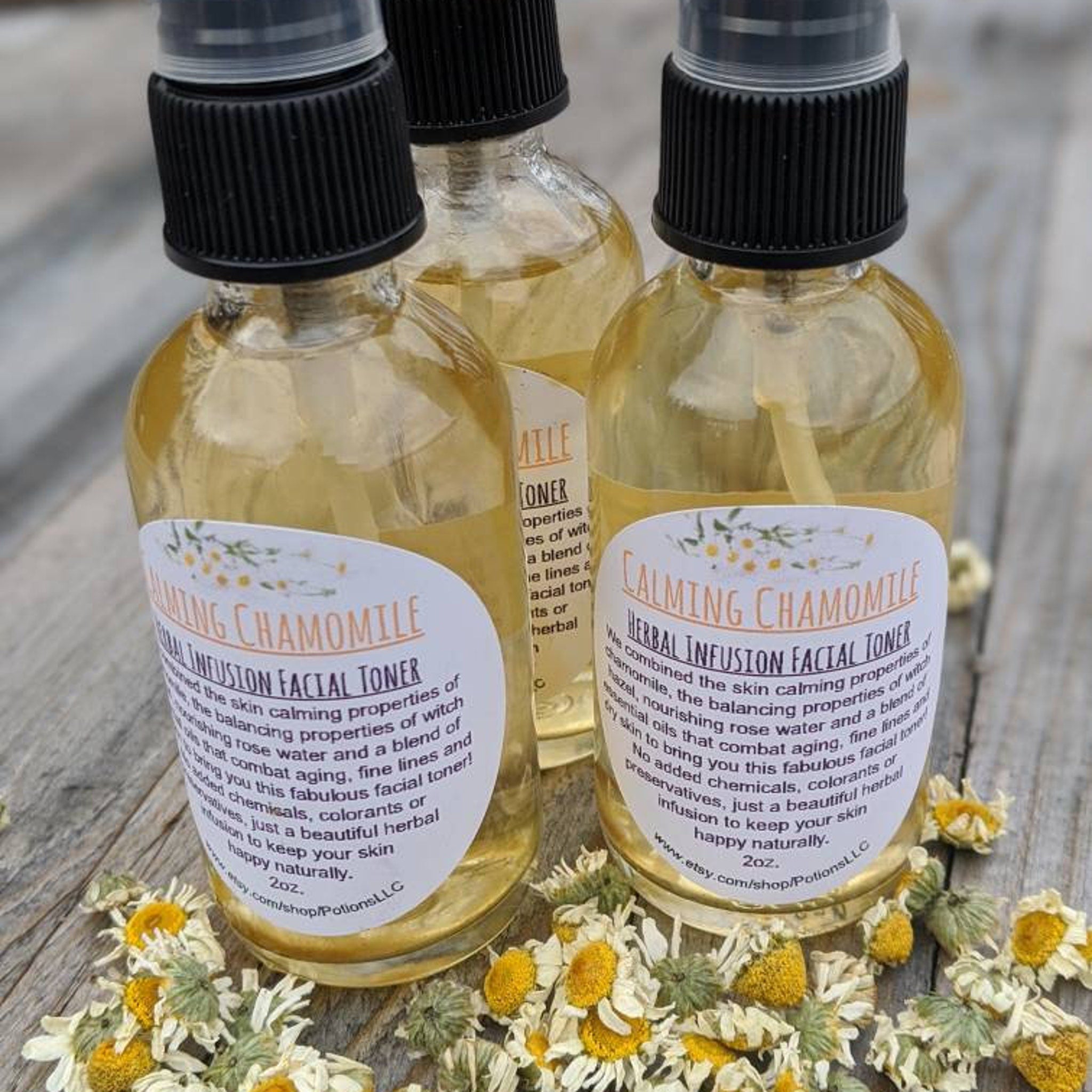 Facial toner bottles with yellow liquid, black caps, and white labels with PotionsLLC text, surrounded by flowers