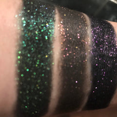Eyeshadow swatches with green, brown, and purple glitter, applied on skin, showing different color shades