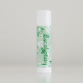 Eucalyptus lip balm with white cap and green patterned label, Forest Hills Remedies text visible