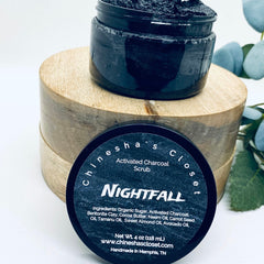 Activated charcoal scrub in black jar with wooden base and label, "Nightfall