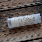 Lip balm tube with clear plastic, white label, and "Blue Raspberry Slushie" text