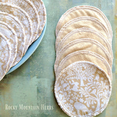 Nursing pads with beige fabric, white floral pattern, and white stitched edges, by Rocky Mountain Herbs