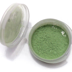 Close-up of shimmery pistachio eyeshadow being applied to eyelid with brush, showcasing light spring green pigment.