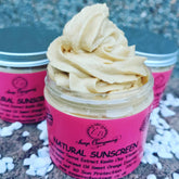 Natural sunscreen cream in a clear jar with pink label, light brown whipped texture, and Essential Boutique branding