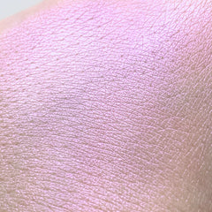 Close-up of vibrant purple pressed powder eye shadow with shimmer finish in compact case